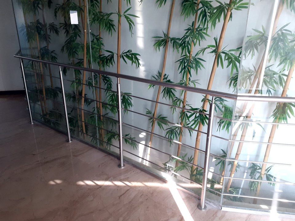 Stainless steel and glass railing in a planted atrium