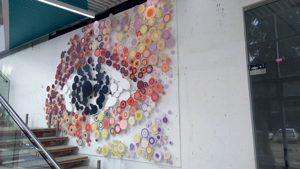 A sculptural wall installation set beside a staircase, finished to match the surrounding scheme.